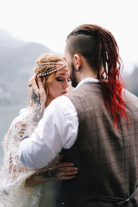 A happy couple in love and married embrace in nature by the lake and the misty mountains