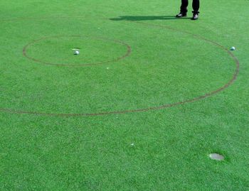 Low section of man standing at golf course