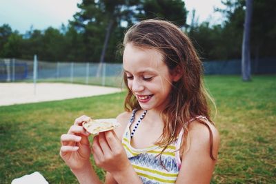 Close-up of young woman eating food in park