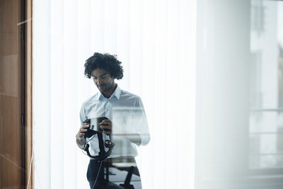 Young businessman looking at virtual reality simulator in office board room