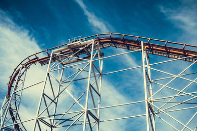 Low angle view of ferris wheel against blue sky