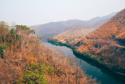 Scenic view of river by mountains against sky