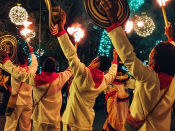 People holding fire and hat during festival