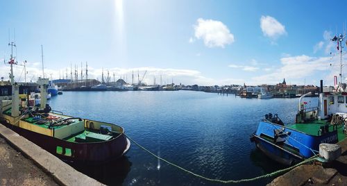 Boats at harbor against blue sky