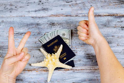 Cropped hands of woman gesturing by objects on table