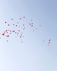 Low angle view of balloons flying against clear sky