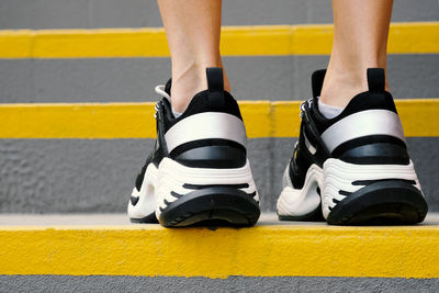 Close-up of sneakers on female legs on the stairs in the stadium, rear view. female muscular legs 