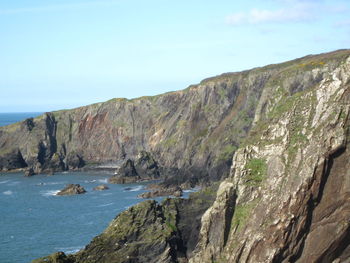 Scenic view of sea and mountains against sky