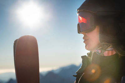 Close-up, ski goggles and a woman's face in a ski resort against the backdrop of mountains and sky