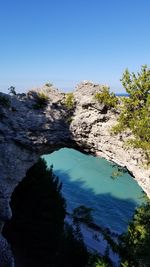 High angle view of rocks in sea against clear blue sky