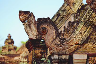 Low angle view of statues on building against sky