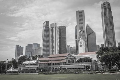 Buildings in city against cloudy sky