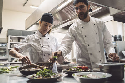 Low angle view of chefs preparing food in commercial kitchen