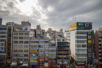 Low angle view of buildings against cloudy sky