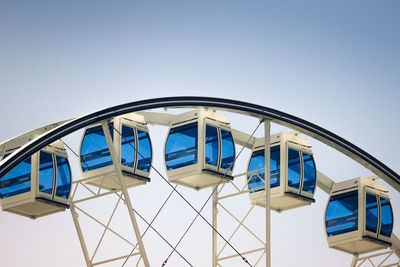 Low angle view of amusement park against clear blue sky