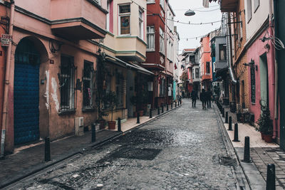 People walking on footpath amidst buildings in city