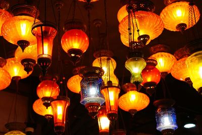 Illuminated lanterns hanging at market stall