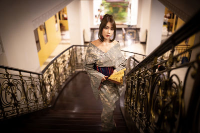 Portrait of woman standing on staircase