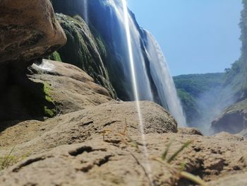 Scenic view of waterfall against rocks