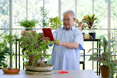 Man standing by potted plants on table