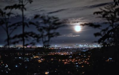 Illuminated cityscape against sky at night