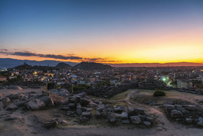 Aerial view of buildings in city during sunset