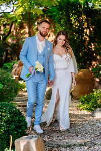 Portrait of happy couple walking against trees