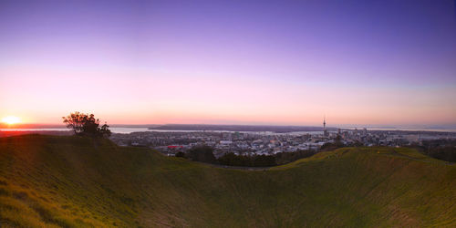 Aerial view of illuminated cityscape against clear sky during sunset