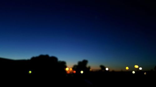 Silhouette trees against sky at night