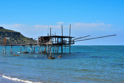 Pier over sea against blue sky