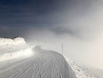 Snow covered land against sky