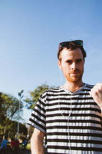 Portrait of man standing against blue sky