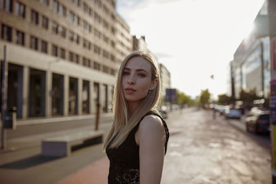 Portrait of beautiful young woman standing on street in city