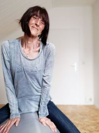 Smiling mature woman sitting at home