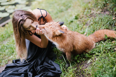 Side view of woman with goat on field