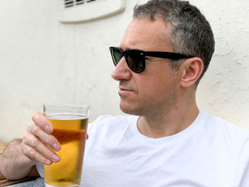 Middle aged man is drinking beer in a cafe or restaurant pub outdoor. drinking alcohol. candid