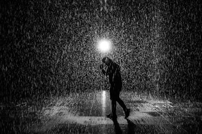 Full length of man with umbrella standing in rain