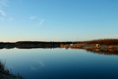 Scenic view of lake against clear blue sky