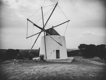 Traditional windmill on field against sky