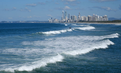 Person riding jet boat on sea against sky