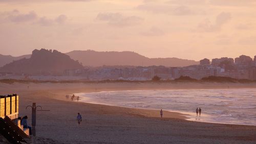 High angle view of people on beach against sky during sunset