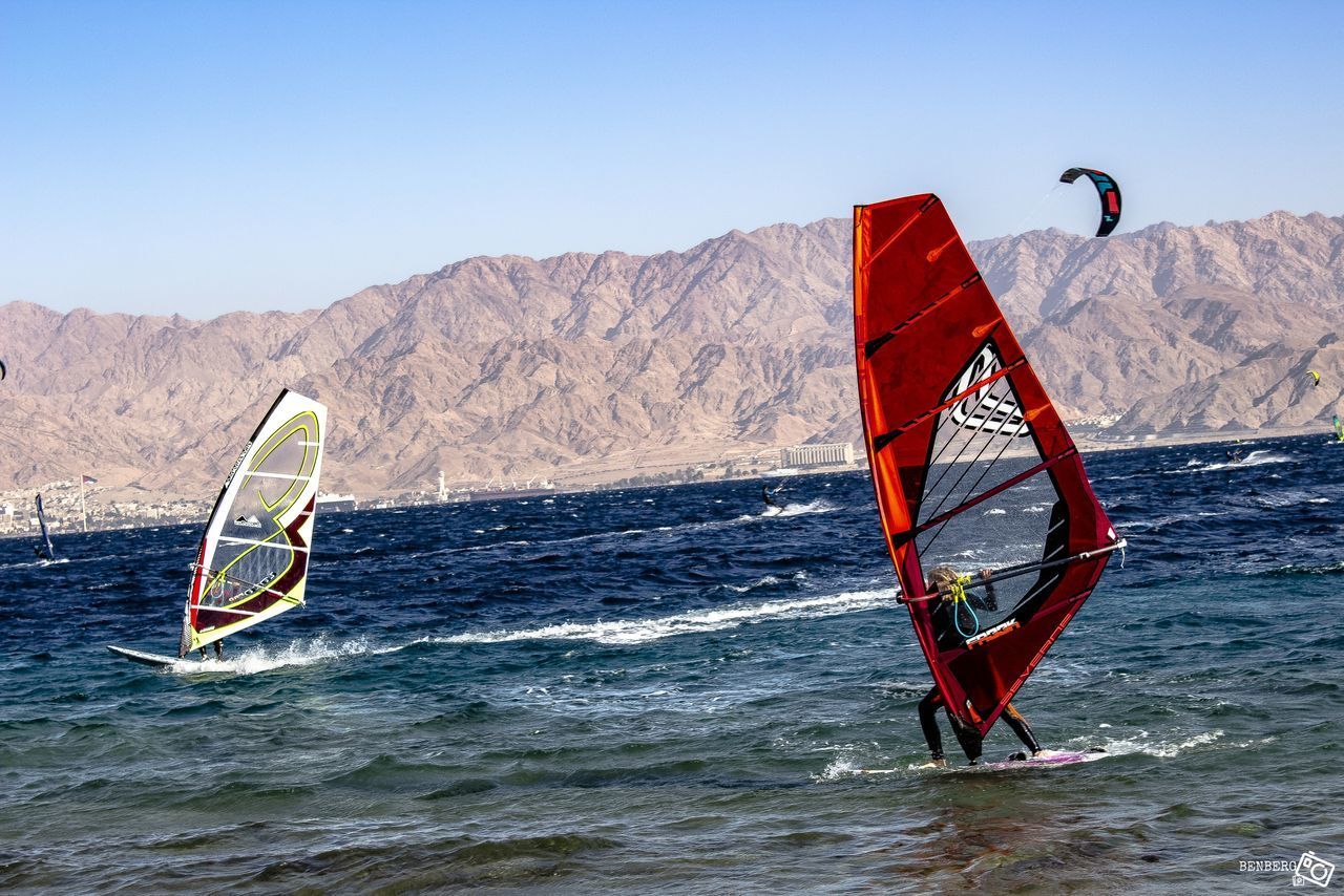 DECK CHAIRS ON SEA AGAINST MOUNTAIN