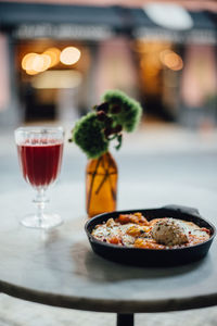 Shakshouka and a glass of beetroot juice on the table in a cafe