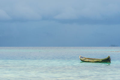 Boat moored in sea against sky