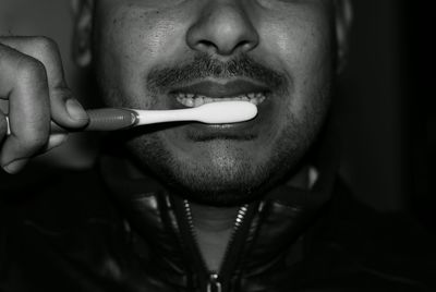 Cropped image of man brushing teeth