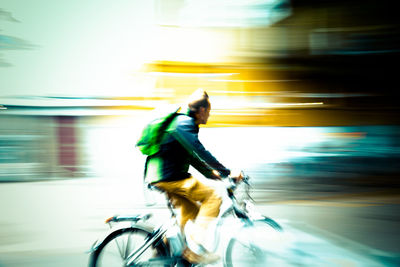 Side view of man riding bicycle on road