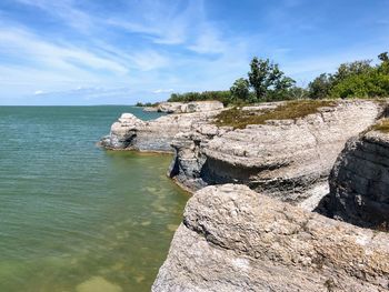 Rock formations by sea against sky