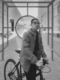 Portrait of young man with bicycle outdoors