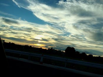 Silhouette of trees against cloudy sky