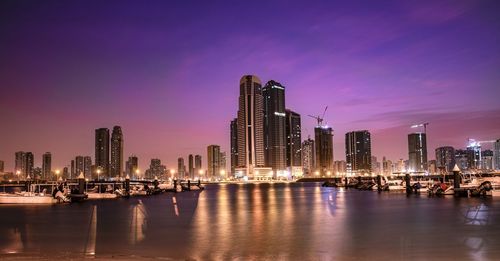 Illuminated buildings in city against sky at night